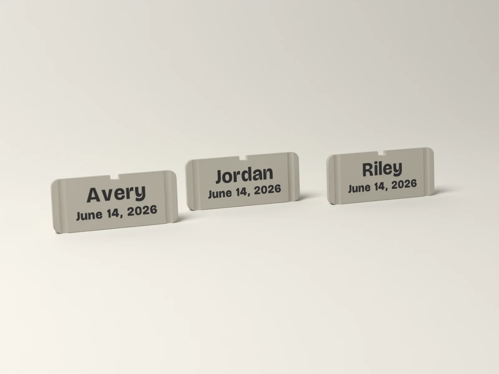 Three fluted place cards in Gallery reading Avery, Jordan and Riley, each standing on its cut edge