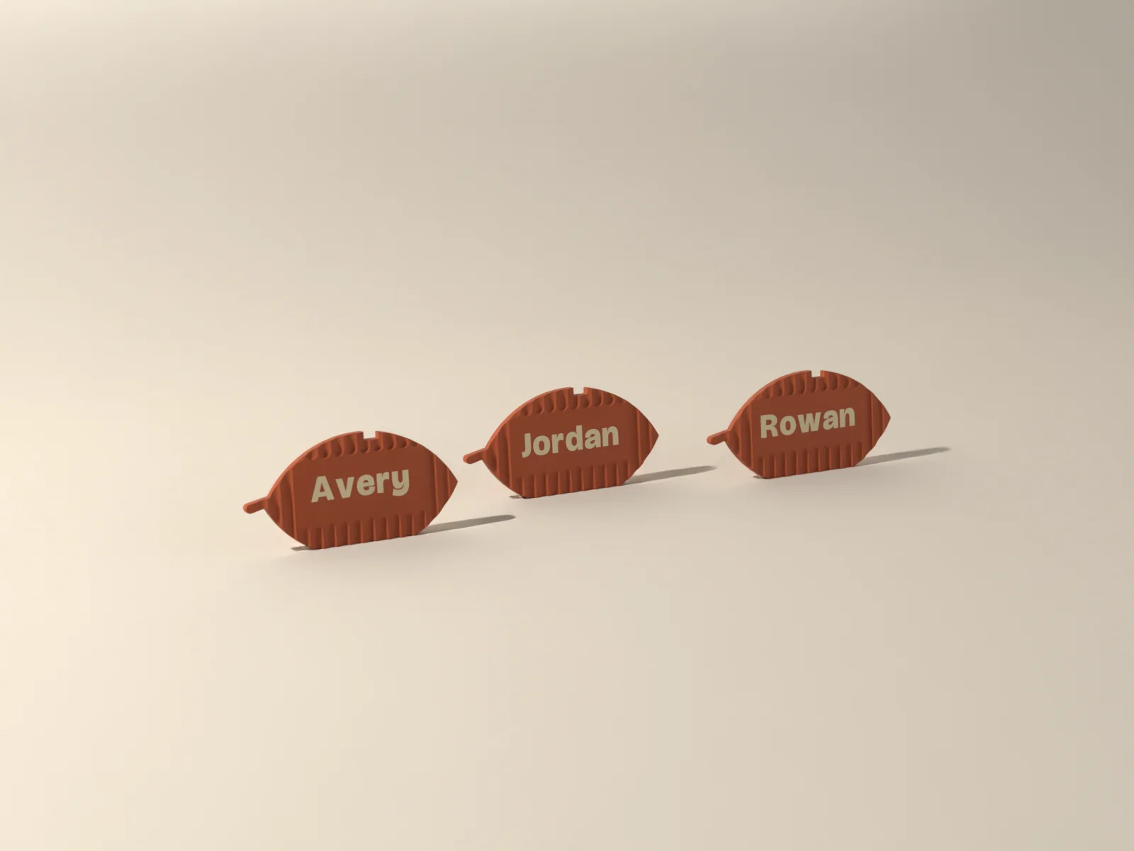 Three harvest place cards, a leaf, a pumpkin and an acorn in Kiln terracotta, each with a name inlaid in sand