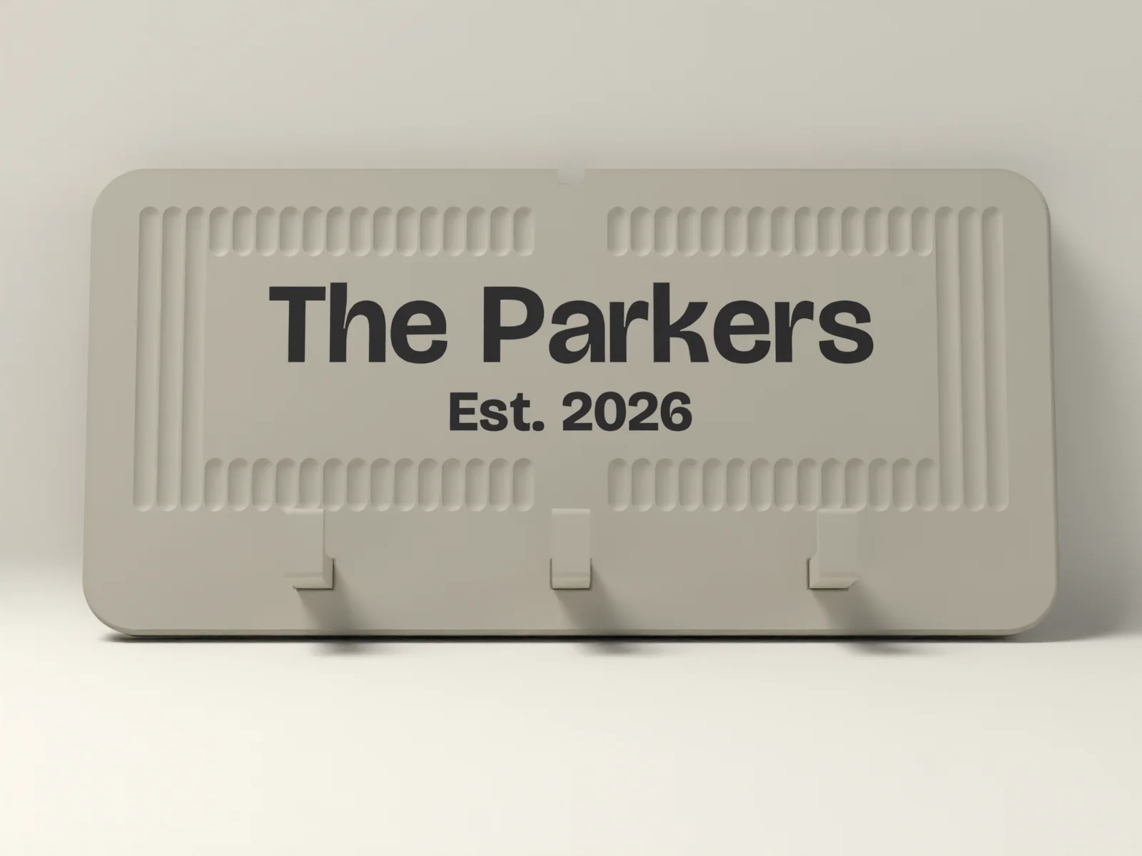 Wall key holder from the front, the family name and date inlaid flush on a smooth panel