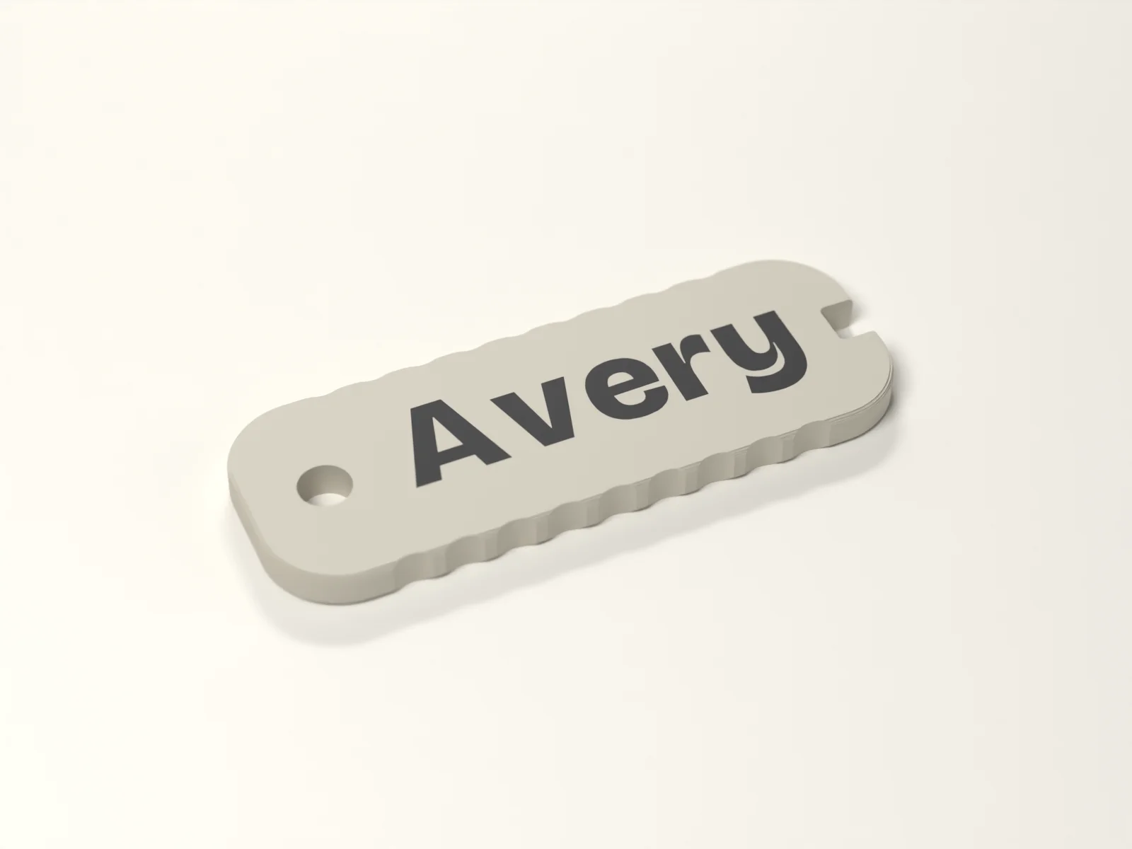 Name keychain, three quarter view, showing the fluted edge and the keyway notch at the far end