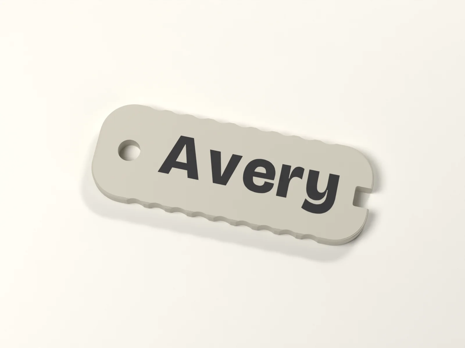 Name keychain from above, the name inlaid flush between the ring hole and the keyway notch