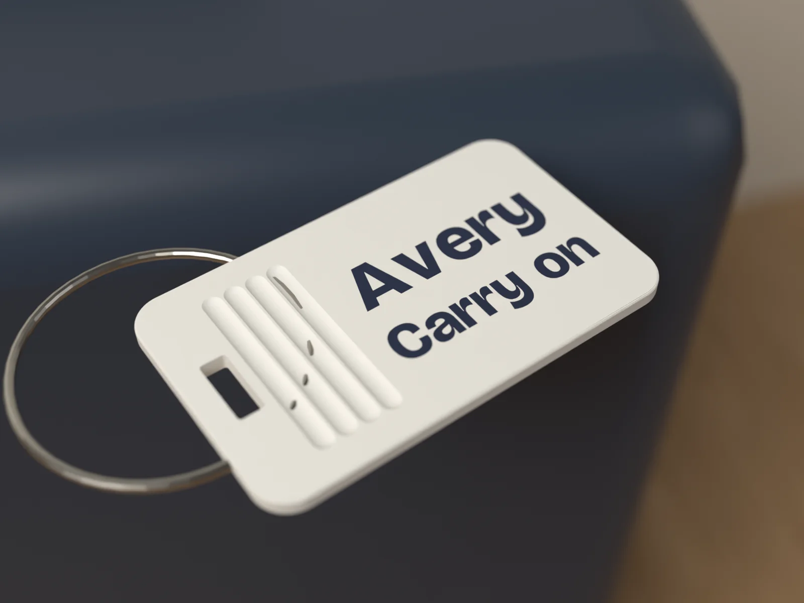 Luggage tag in Mariner lying on top of a navy suitcase with its steel cable loop